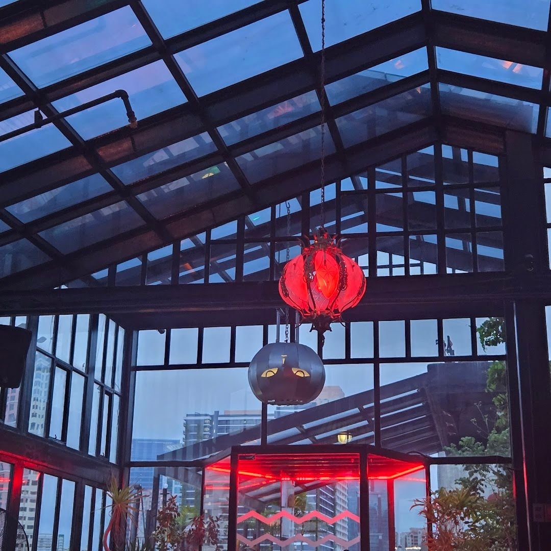 Seltsam glass house at twilight with red accent lighting and city skyline